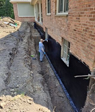 Excavate to expose basement wall and install waterproofing material. Backfill with peastone and sand.